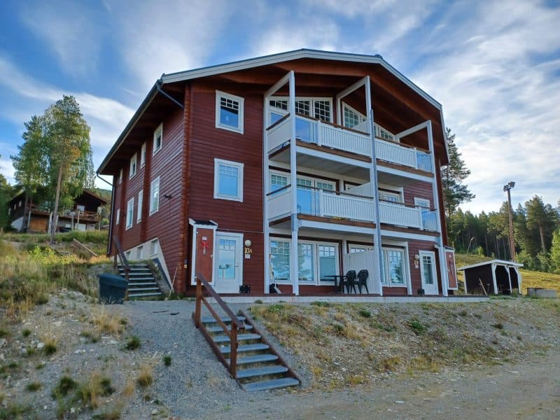 Exterior view of a mountain house with several apartments on three levels.