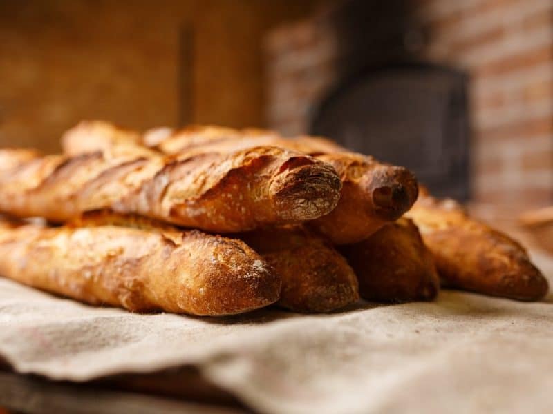 Baguettes in front of a wood oven