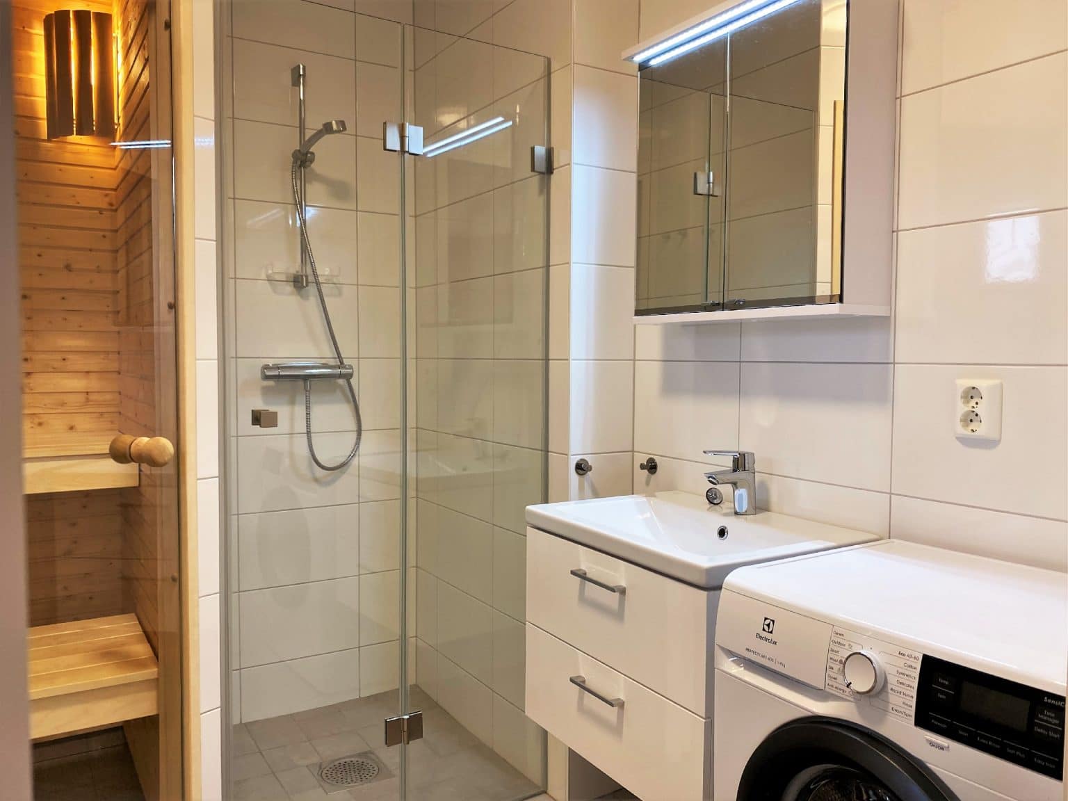 Badrum med bastu, tvättmaskin och dusch